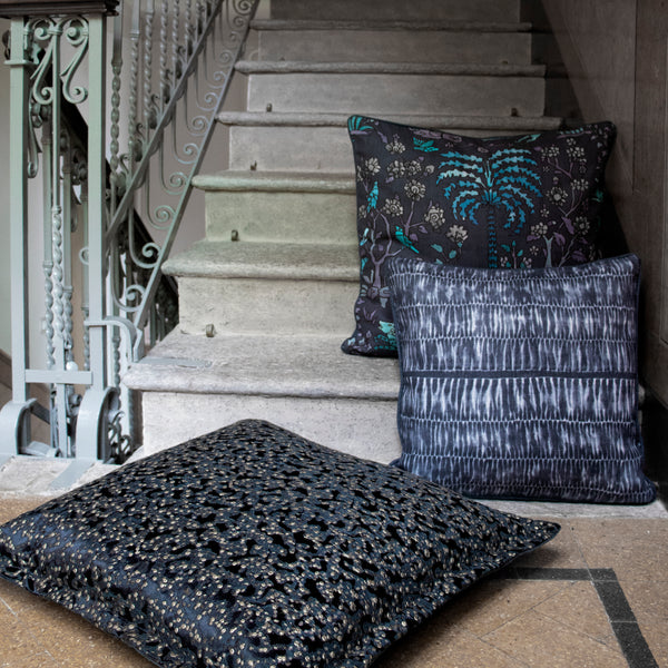 Multiple blue patterned pillows atop a staircase