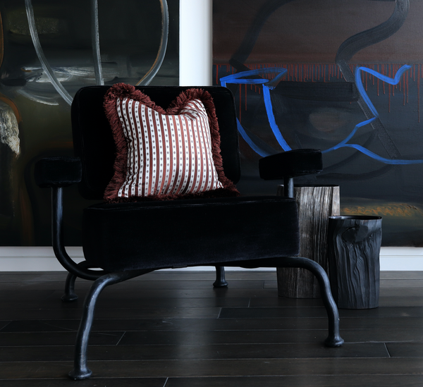 Luxurious chestnut striped cushion atop a dark velvet chair